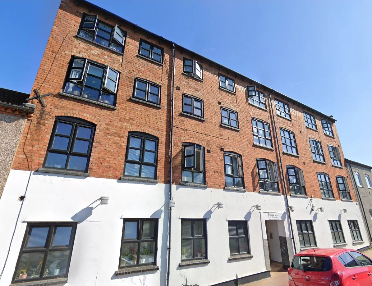 Commercial mixed-use building with clean brick facade and restored render