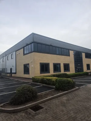 Before - commercial building buff brick metal cladding facade algae weathering, Rugby.