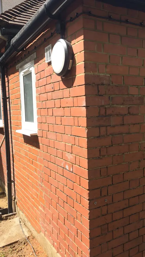 Before - red brick wall with green algae in mortar joints, Luton.