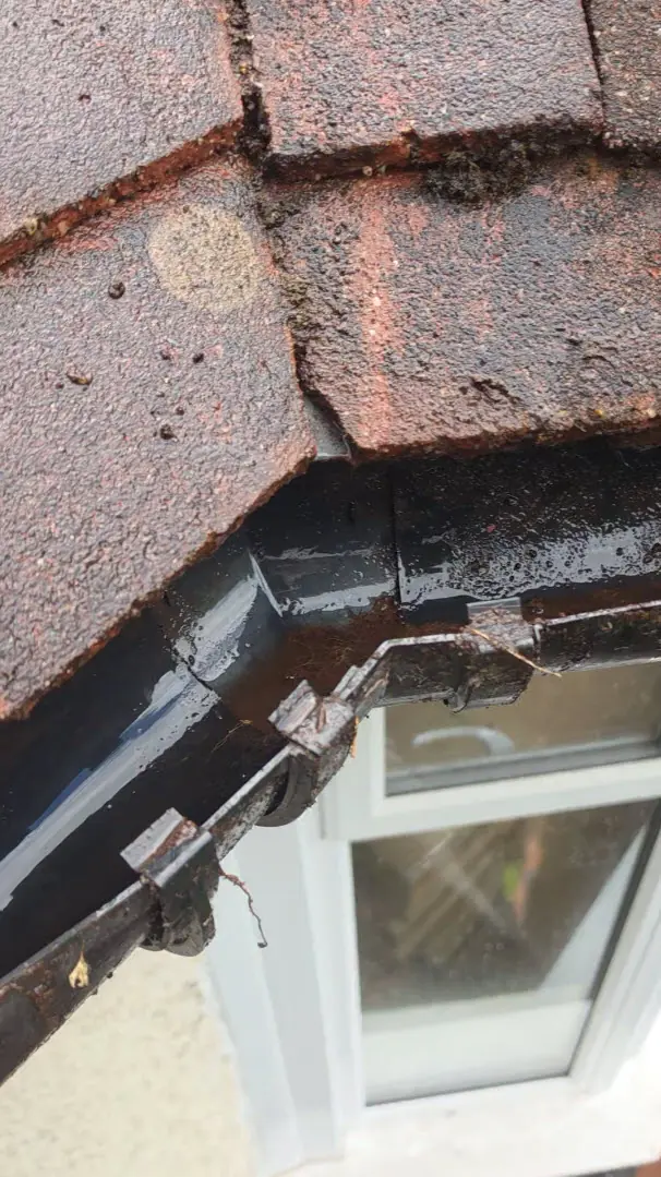 Before - black gutter blocked with moss and debris, Luton.