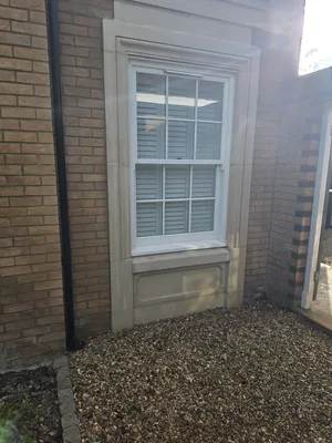 After - residential red brick wall stone window surround cleaned, Orlingbury.