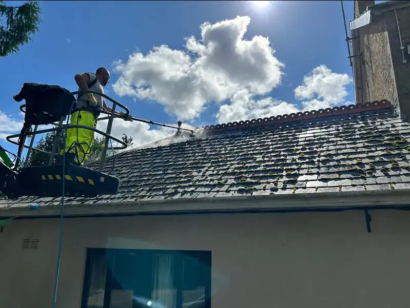 Soft washing a tiled roof at low pressure from a MEWP cherry picker